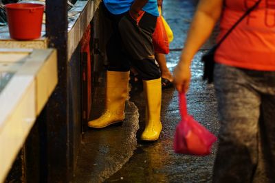 Low section of people standing on wet street