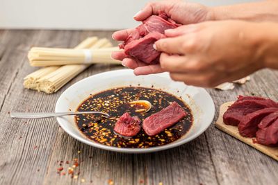 Close-up of woman preparing food on cutting board