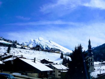 Snow covered houses and buildings against sky