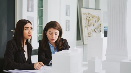 Portrait of smiling young woman standing against building