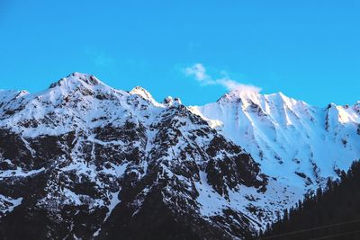 Scenic view of snowcapped mountains against clear blue sky