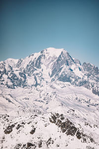 Scenic view of snowcapped mountains against clear blue sky