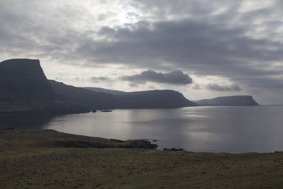 View of calm sea against mountain range