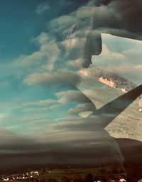 Airplane flying over landscape against sky