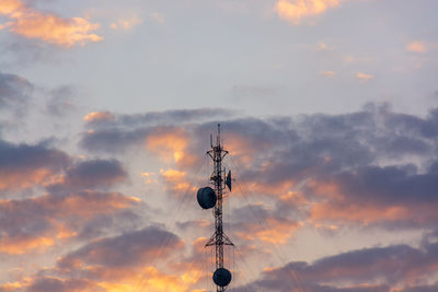 Low angle view of communications tower against sky during sunset