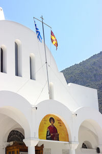 Low angle view of flags on building against sky