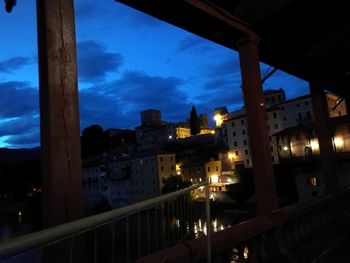 Illuminated buildings against sky at dusk