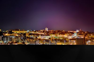 Illuminated buildings against sky at night