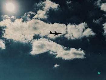 Low angle view of airplane flying against sky