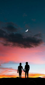 Silhouette friends standing against sky during sunset