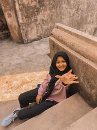 Portrait of a smiling young woman sitting outdoors