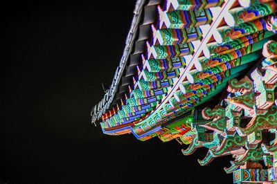 Low angle view of colorful lanterns hanging against black background