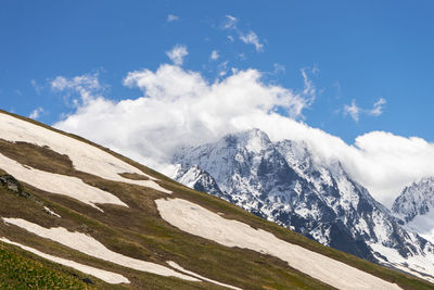 Scenic view of snowcapped mountains against blue sky