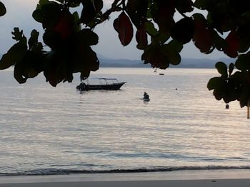 Silhouette boats in calm sea against the sky