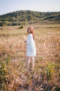 Portrait of woman standing on field