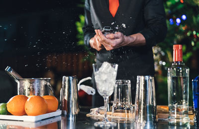 Midsection of man preparing food in glass container