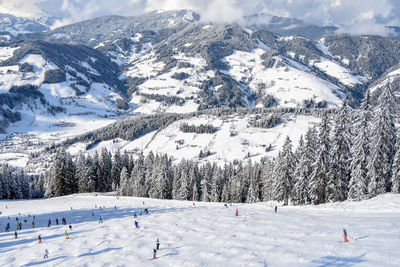 Panoramic view of people skiing on snowcapped mountain