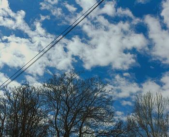 Low angle view of bare tree against cloudy sky