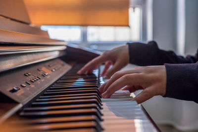 Cropped hands playing piano