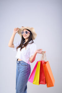 Young woman wearing sunglasses against gray background