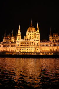 Low angle view of illuminated buildings against sky at night