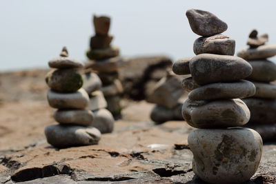 Stack of pebbles on rocks against sky