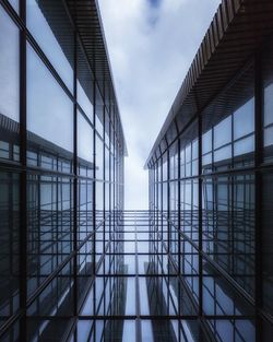 Directly below shot of modern glass building against sky