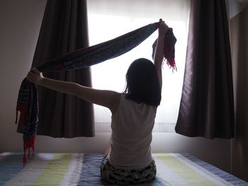 Rear view of girl standing at home