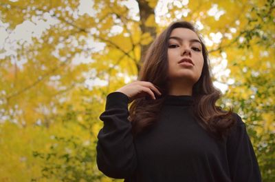 Portrait of a beautiful young woman standing against plants