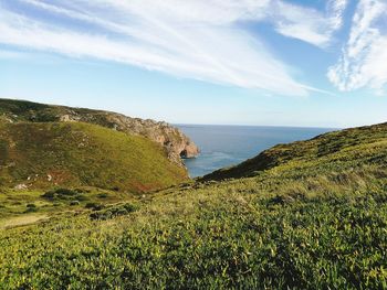 Scenic view of cliff and sea against sky