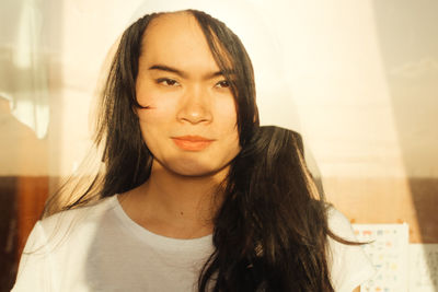 Close-up portrait of young woman at home