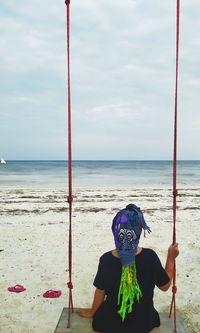 Full length of person with umbrella on beach against sky