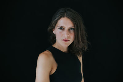 Portrait of a beautiful young woman over black background