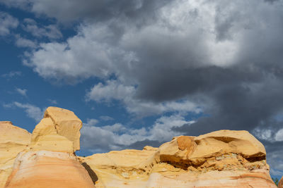 Landscape of yellow rock formation tops and dark clouds in the ojito wilderness in new mexico
