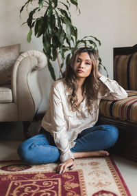 Young woman sitting on sofa at home