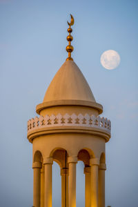 Low angle view of minarets against sky and full moon