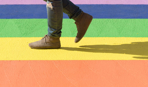 Low section of man walking on colorful street