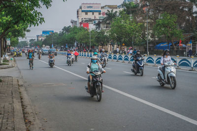 People riding bicycle on road in city