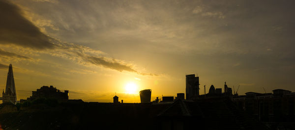 Silhouette buildings against sky during sunset