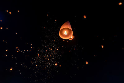 Low angle view of illuminated lantern against sky at night