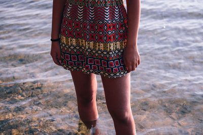 Low section of woman standing in water