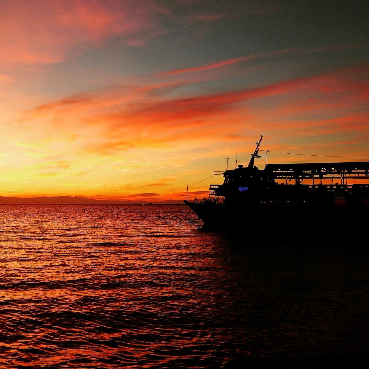 SILHOUETTE BOAT IN SEA AGAINST DRAMATIC SKY