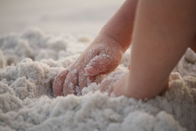 Close-up of hand on sand at beach