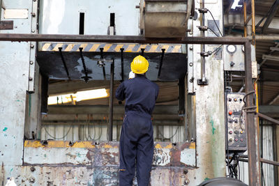 Rear view of worker working in factory