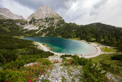 Scenic view of lake by mountains against sky