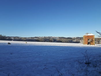 View of snow covered landscape against blue sky