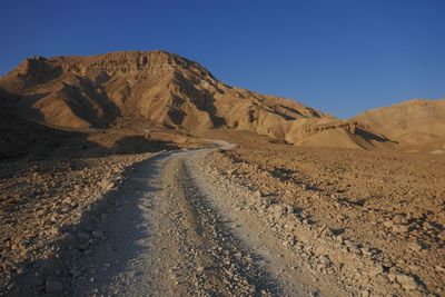 Scenic view of desert against clear blue sky