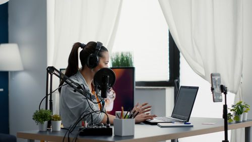 Side view of woman using laptop at table