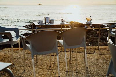 Chairs and tables at restaurant by sea