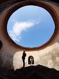 Low angle view of woman standing against sky